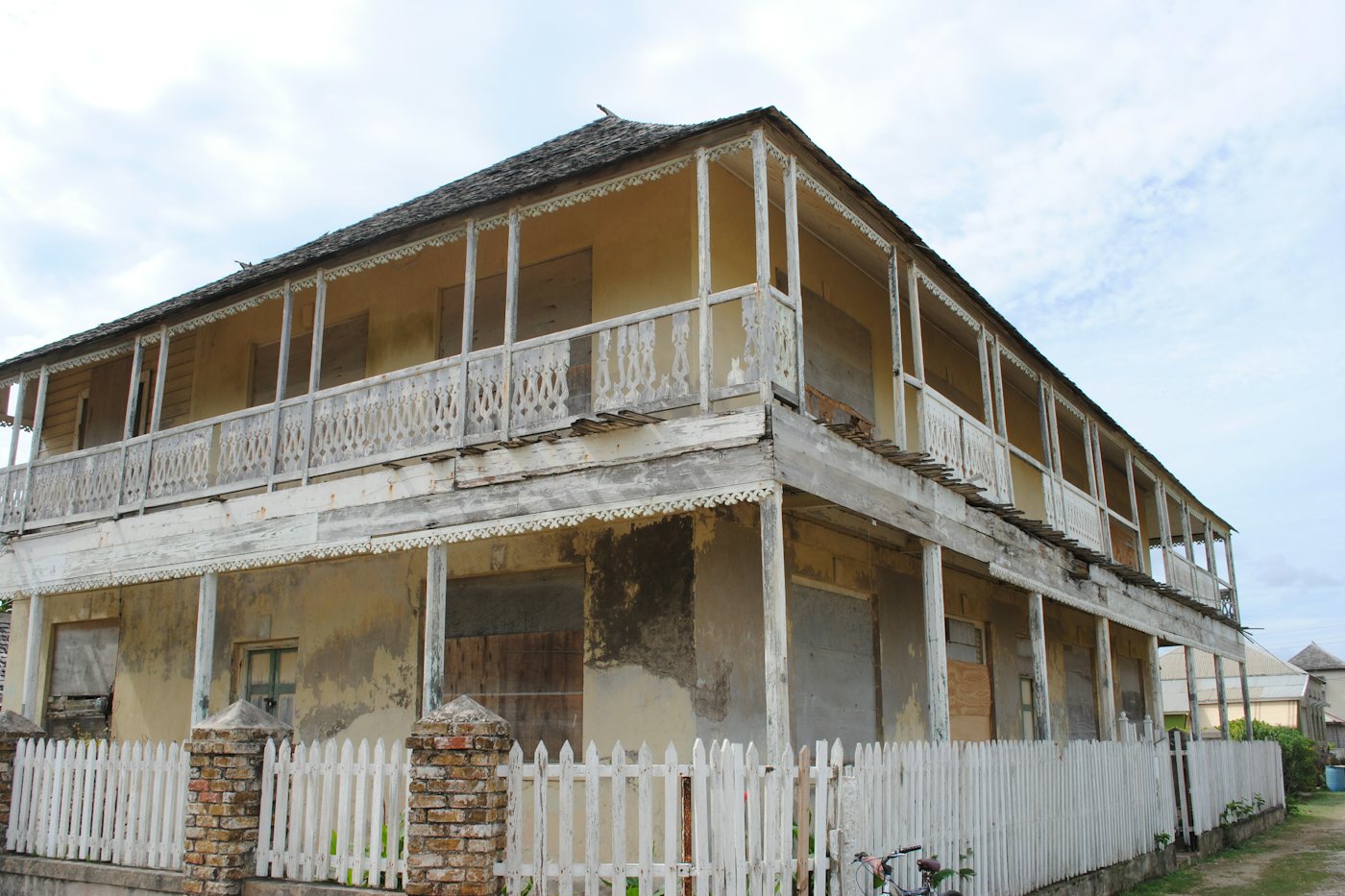 Historic two-storey timber house with a white picket fence in Falmouth, Trelawny, Jamaica